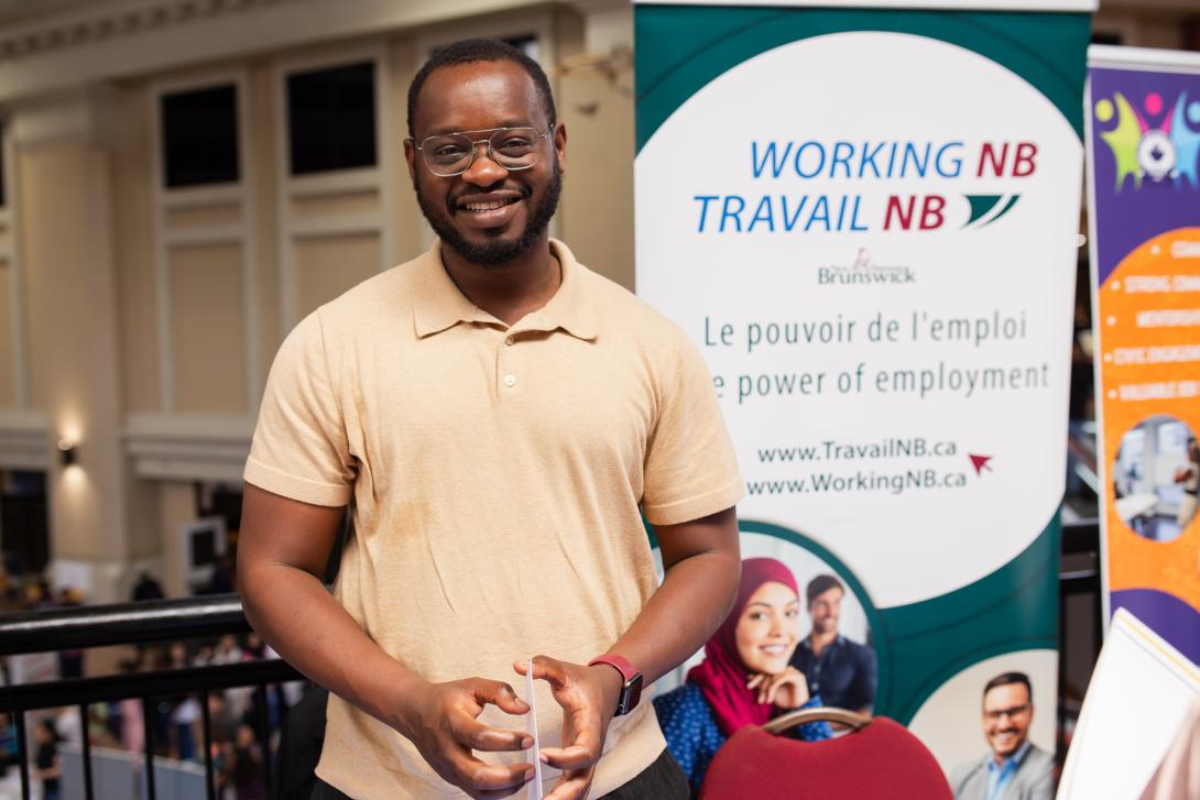 Man standing in front of a WorkingNB banner