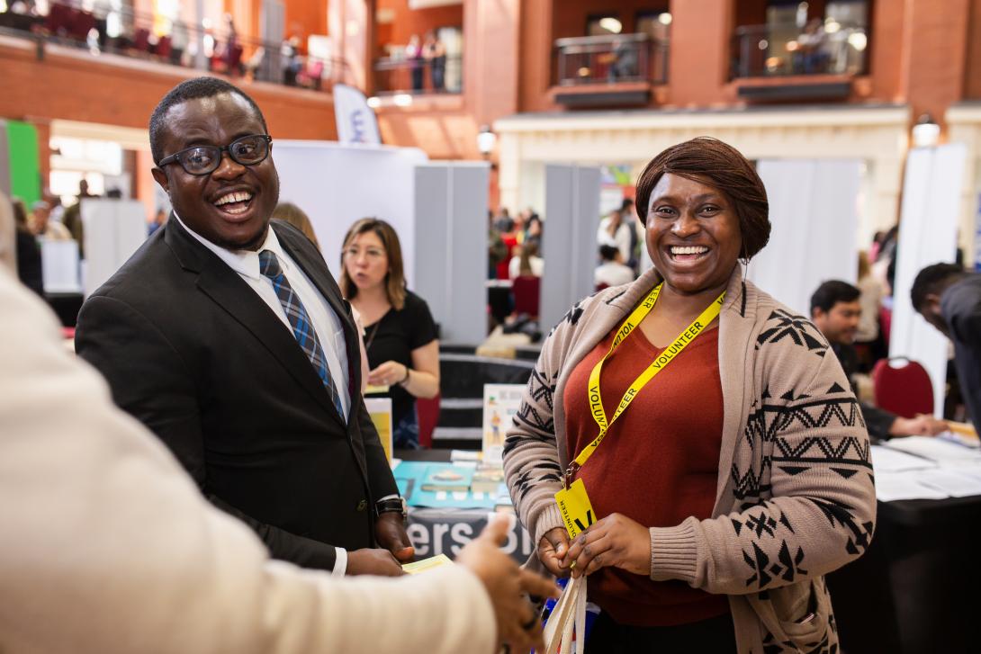 Two people smiling at a job fair