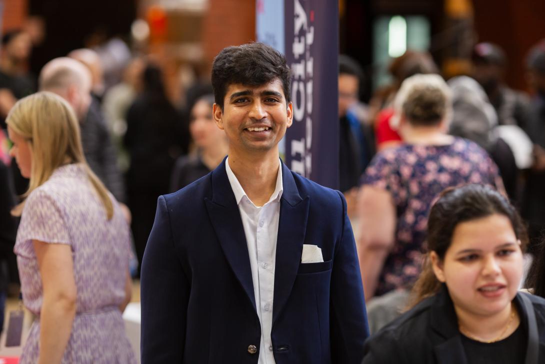 Person standing in a crowd at a job fair