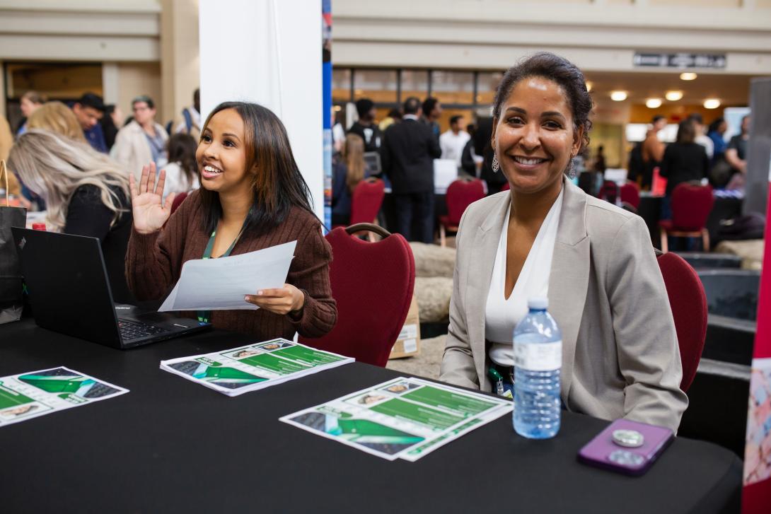 Two woman sitting at a table smiling