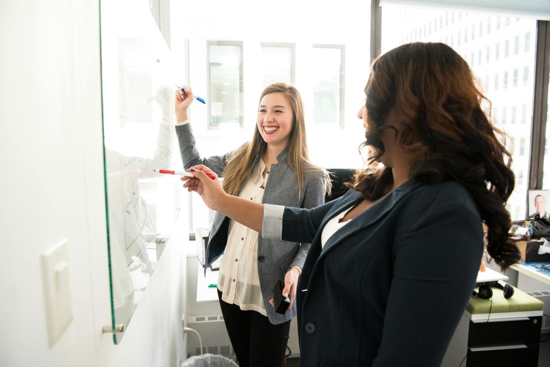 Two people standing at a whiteboard