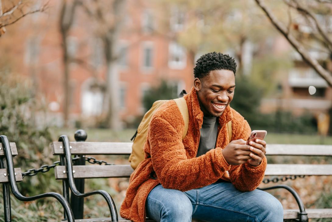 Someone texting on their phone while smiling