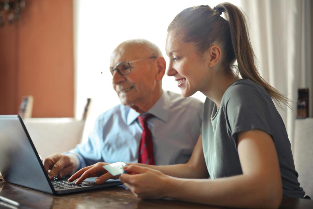 Two people sitting at a laptop smiling